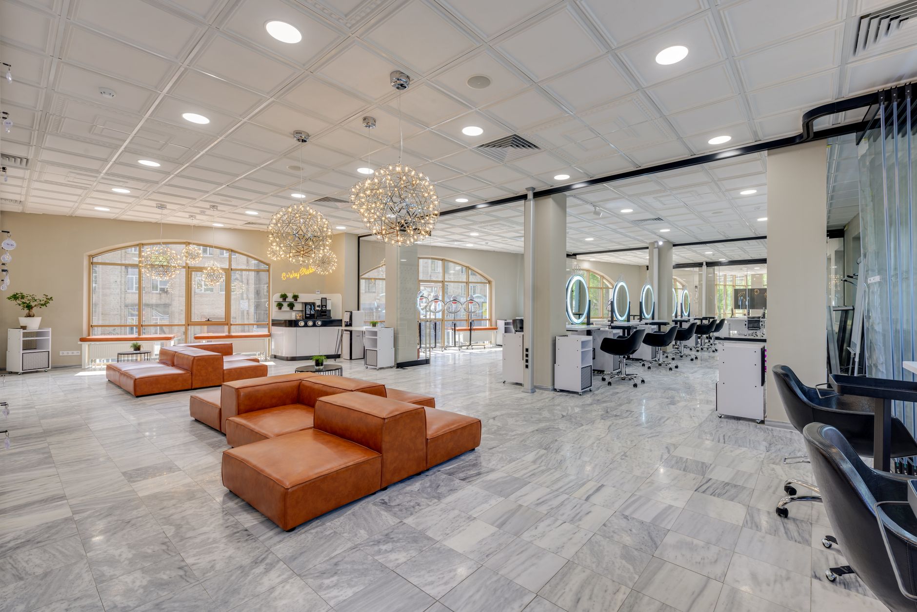 Bright, elegant interior of an established salon with natural light and leather seating